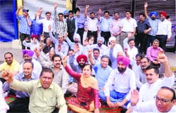 Shopkeepers of the Model Town market sit on a dharna against the imposition of property tax along with former MLA Jagbir Brar and Congress leader Rajinder Beri at the market in Jalandhar on Thursday. Photo: Sarabjit Singh