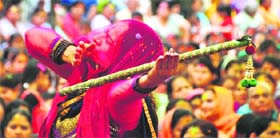 A Lord Krishna devotee dances during the Holi celebrations at Govind Gau Dham
