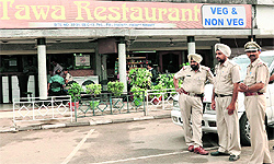 Police personnel outside Tawa Restaurant from where the three youths were kidnapped at gunpoint in Sector 10, Panchkula, on Friday