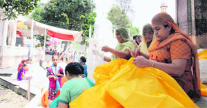 Women devotees stitch gilaaf for the annual Jhanda Sahib mela at Sri Guru Ram Rai Darbar in Dehradun on Friday. 
