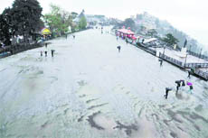 People walk during a hailstorm in Shimla on Friday.