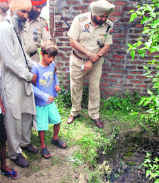 Police inspects the site from where Rohit was rescued from a well at Bulandpur village in Jalandhar on Friday. 