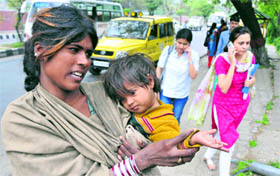 A beggar with her child asking for alms outside the University of Jammu.