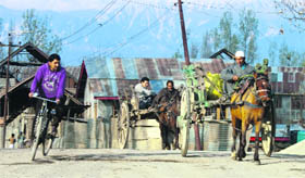 People ride a horse cart in Budgam on Friday.