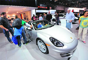People view a 2013 Porsche Boxster at a public preview of this years New York International Auto Show on Friday in New York.