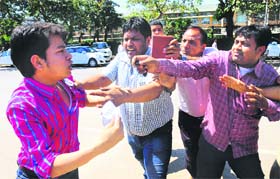 A trader (in pink shirt) manhandles the enforcement staff of the MC during an anti-encroachment drive conducted at Industrial Area, Phase 1, Chandigarh, on Saturday