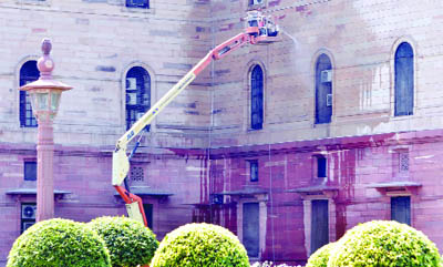 A worker cleaning the walls of South Block in New Delhi on Saturday. 