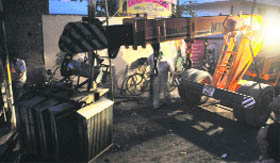 A crane lifts the transformer that fell on the foot of a child in New Kundanpuri on Saturday.