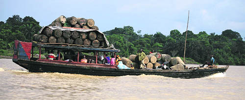 People travel on a locally built passenger boat loaded with oil containers through a creek on the River Nun in Bayelsa, Nigeria.