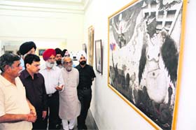 IAFA president Rajinder Mohan Singh Chhina and other visitors look at a painting during an art festival at the Indian Academy of Fine Arts in Amritsar on Sunday