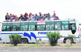 Throwing norms to wind: An overloaded bus plies on a road in Amritsar on Sunday