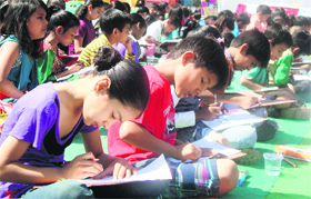 Children take part in a drawing competition in the Khuda Lahora Colony on Sunday.
