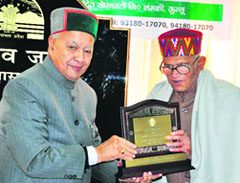 Chief Minister Virbhadra Singh honours Satyen Sharma with a lifetime achievement award in literature in Shimla on Sunday.