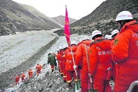 Rescuers march to a gold mine after a landslide in Maizhokunggar County in Tibet on Saturday