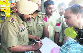 Policemen recording statements after a man committed suicide at his shop in Parasram Nagar on Monday.