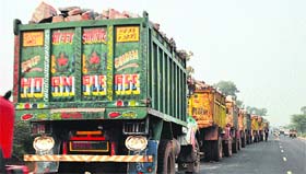 A caravan of dumper-trucks loaded with stones on the Mewat-Gurgaon Road