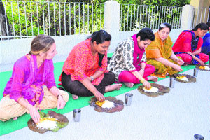 Elizabeth, a US research scholar, Poornima Dutta, Director, and Maalvika Pathania, convener, INTACH, respectively, enjoy a Kangri dham at GAV Public School in Kangra on Monday.