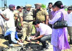 Forensic experts take samples from the charred remains of the body of a woman in Jalandhar on Monday. Tribune photo: Malkiat Singh