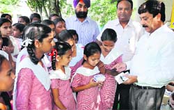 Civil Surgeon Dr RL Bassan make school students aware of iron tablets in Jalandhar on Monday. Photo: Sarabjit Singh