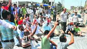 Residents protest at Chander Nagar in Ludhiana on Monday.