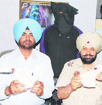 Police officials show two pistols recovered from a looters gang in Amritsar on Tuesday. 