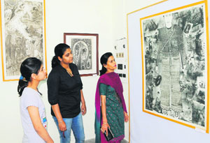 Visitors have a look at paintings during the week-long Graphic Art Exhibition in Amritsar on Tuesday.