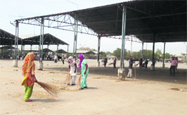 Workers clean the grain market in Muktsar on Tuesday.