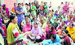Hargobind Kaur, president of the Anganwari Mulazim Union, addresses workers at a meeting held at the Zila Parishad office in Bathinda on Tuesday