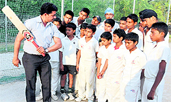 Coach Ravi Kumar gives cricketing tips to budding players the Government Rajindra College grounds in Bathinda on Tuesday