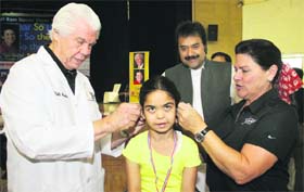 William Franklin Austin of the Star Key Hearing Foundation (USA) and his wife fix hearing aids to the ears of a hearing impaired child at DAVIET in Jalandhar on Tuesday