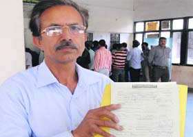An applicant of ration card shows a copy of Rs 5 challan to be deposited with a bank in Jalandhar