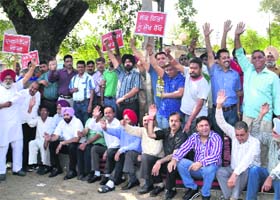 Shopkeepers, supported by Congress councillors, hold a protest against the imposition of property tax on Ladowali Road in Jalandhar on Tuesday