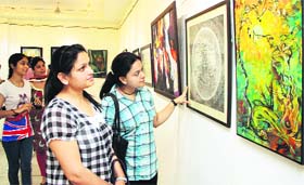 Adoring art: Visitors look at paintings at an exhibition at Virsa Vihar in Jalandhar on Tuesday