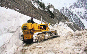 A Beacon bulldozer clears snow from a treacherous road at Zojila Pass on Tuesday. 