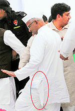 Anna Hazare walks off the stage with a torn kurta after people jostled to get clicked with him