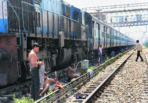 Passengers bathe on the railway track at the Chandigarh Railway Station.