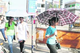 Beating the heat Girls use umbrella while going out in the sun in Bathinda on Thursday