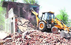 A structure being pulled down at Raipur Kalan village in Chandigarh on Thursday. 