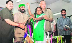 Chief Minister Vijay Bahuguna and Education Minister MP Naithani present a bicycle to a girl student in Dehradun on Thursday. 