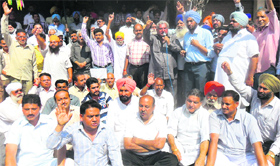 Shopkeepers, supported by Congress leaders, hold a protest against the imposition of property tax at the Lamba Pind Chowk market in Jalandhar on Thursday.