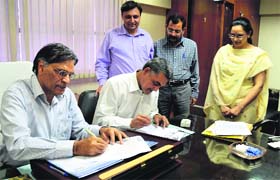 VP Guar, chairman of LSE, (L) and Rajinder Singh, principal of SCD college (R), sign MoU in Ludhiana on Thursday
