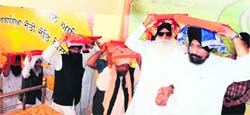 Bhai Gurmej Singh (second from right) carries Guru Granth Sahib prepared in Braille at the Golden Temple complex in Amritsar on Thursday. Photo: Vishal Kumar