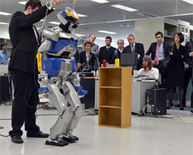 French minister Fleur Pellerin (R) inspecting a demonstration of a humanoid robot HRP-2, which is controlled by human brain activity with the brain-machine interface, in the Japan-France joint laboratory at the National Institute of Advanced Industrial Science and Technology in Tsukuba, Tokyo