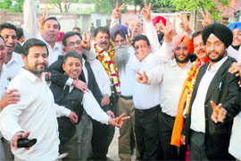 Pardeeep Saini shows the victory sign along with his supporters after winning the Bar association elections in Amritsar on Friday.