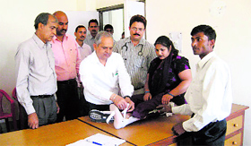 Deputy Commissioner Chander Shekhar gives a Jaipur foot to a needy woman at the Multi-specialty Hospital, Kaithal, on Friday.