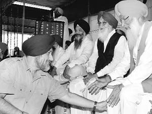 Deputy CM Sukhbir Badal (left) touches the feet of Akali leader SS Dhindsa at the death anniversary of GS Tohra at Tohra village near Patiala on Friday as Chief Minister PS Badal looks on. 