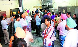 People gather outside the district transport office during the auction of fancy numbers in Amritsar