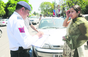 A traffic policeman issues challan near Aroma, Sector 22, in Chandigarh on Saturday.