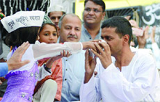 AAP convener Arvind Kejriwal being offered juice by a little girl at Sundar Nagri in northeast Delhi on Saturday.