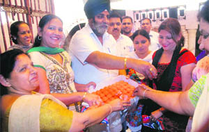 BJP workers exchange sweets on the occasion of the foundation day function of the party in Jalandhar on Saturday. 